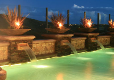 Custom pool with integrated water feature and modern lighting.