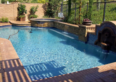 Stunning pool with a waterfall feature and tropical plants.
