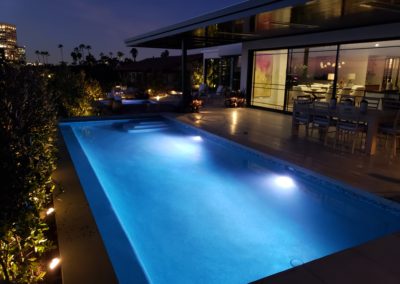 Nighttime view of a luxurious poolscape.